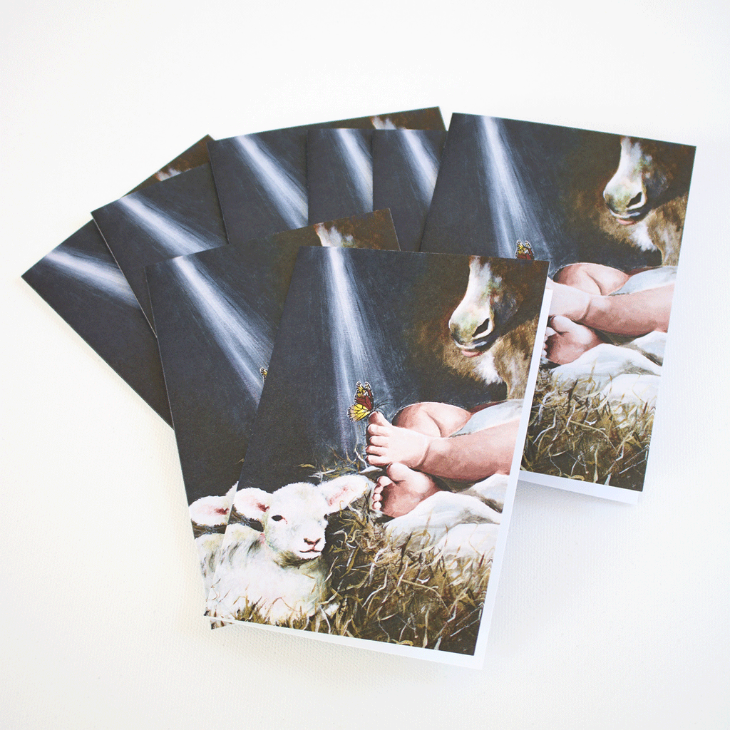 Set of Immanuel Christmas note cards by Mindi Oaten, featuring baby Jesus with a lamb and a butterfly, tied with natural twine — blank Christian art cards.