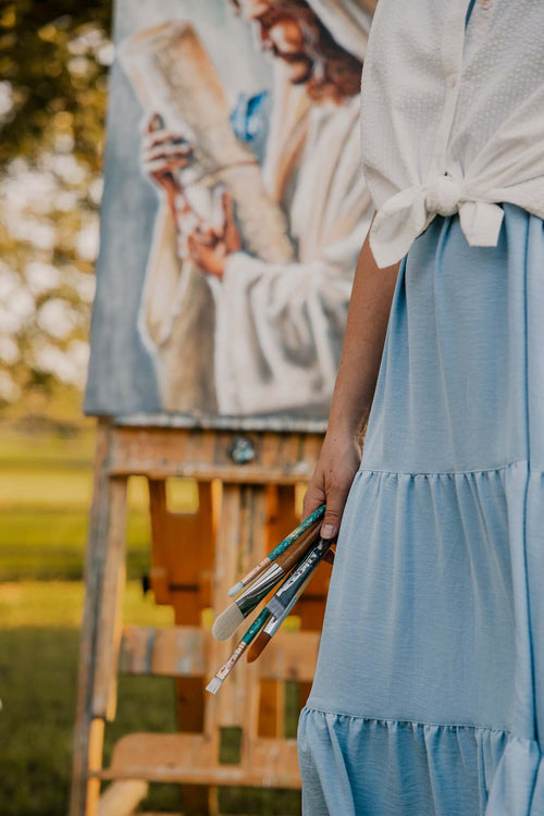 Artist Mindi Oaten with prophetic painting of Jesus, inviting subscribers for new art collections, shows, and messages.