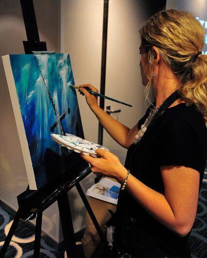 

Mindi painting the blue Anchor for my Soul artwork at an easel.
