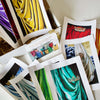 

An open box with colorful drapery prints and an information card.