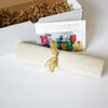 

A tied canvas roll, information card and open gift box.