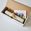

A tied canvas roll and information card inside an open gift box.